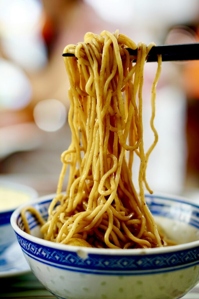 Noodles in a blue and white ceramic bowl